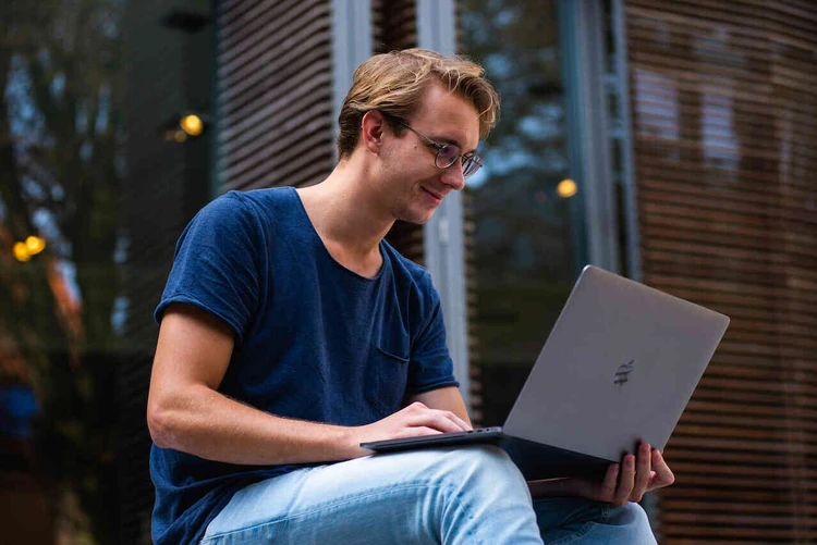 Junger Mann sitzt am Laptop
